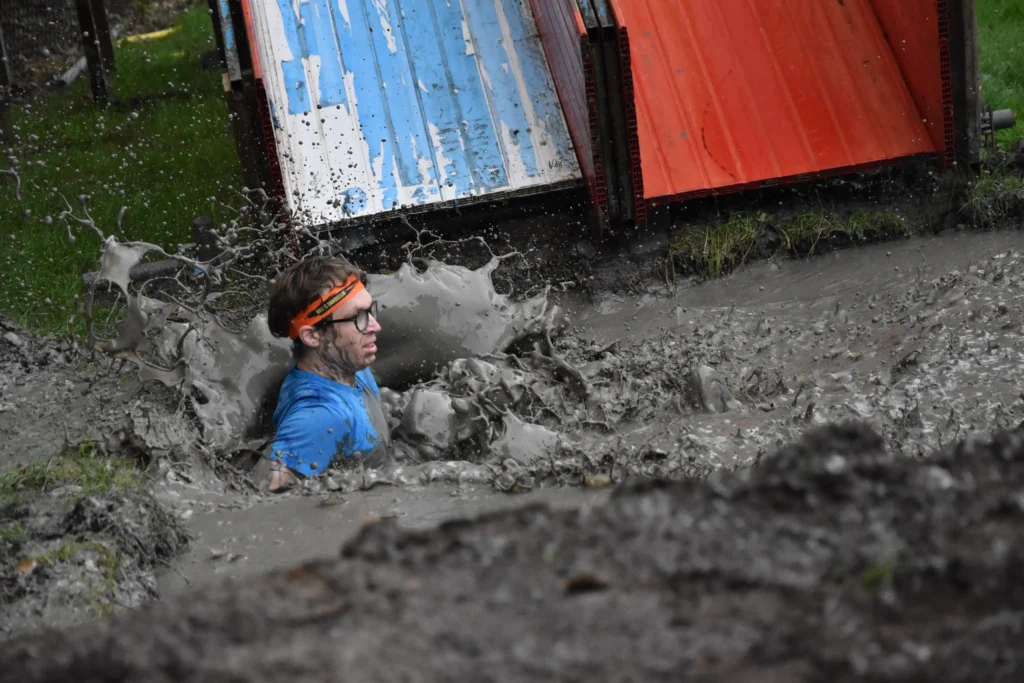 Dirty Monkey Run 2025: deelnemer trotseert een modderobstakel.